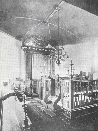 Interieur synagoge met bima, aron kodesh en rechts in de muur de gedenkplaat uit 1907